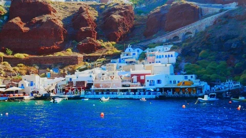 Handheld view of the coastal cliffs of Santorini as seen from a boat on the w Stock-Footage 116088684