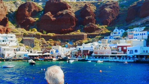 Handheld view of the coastal cliffs of Santorini as seen from a boat on the w 스톡 동영상 116089100