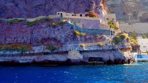 Handheld view of the coastal cliffs of Santorini as seen from a boat on the w Vídeo Stock 116090141