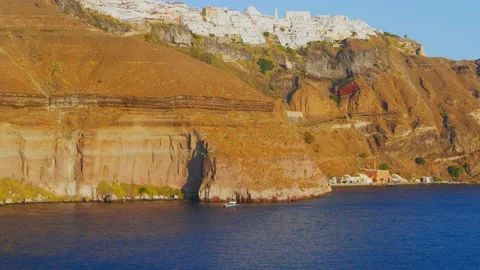 Handheld view of the coastal cliffs of Santorini as seen from a boat on the w Stock-Footage 140215500