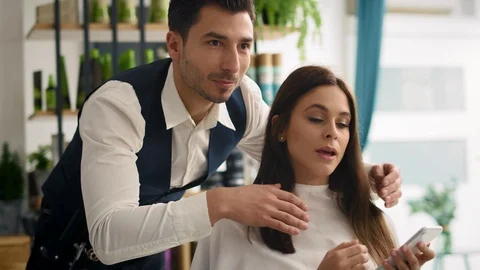 Handheld view of customer showing which hairstyle she wants Stockbeeldmateriaal 125066973