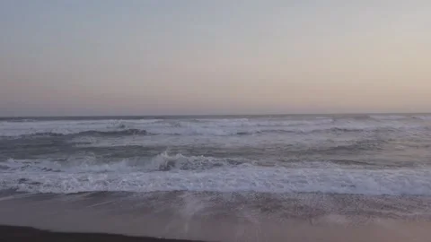 Handheld View of Gentle Ocean Waves Crashing on a Black Sand Beach at Depok Video stock 302524175