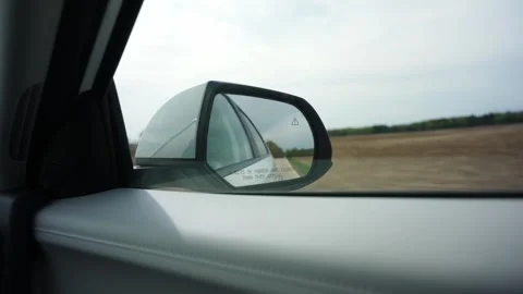 Handheld view from inside a moving car, showing a side mirror, window frame and Stock Footage 341045994
