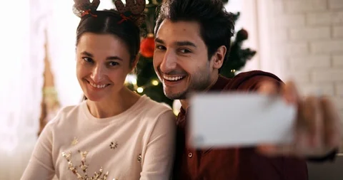 Handheld view of playful couple making a selfie at Christmas Stockbeeldmateriaal 121310457