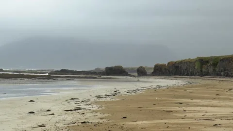 Handheld View of Rugged Sandy Beach and Cliffs in Coastal Iceland 4K Nature Stock Footage 339742265