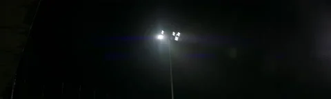 HANDHELD View of stadium flood lights are turning on, heavy rain, bad weather Video stock 221836783
