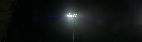 HANDHELD View of stadium flood lights are turning off, heavy rain, bad weather Stock Footage 221837325