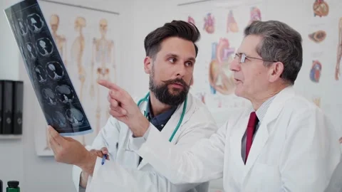 Handheld view of two busy doctors discussing some medical records. Stockbeeldmateriaal 145459868