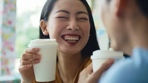 Handheld view of Vietnamese couple drinking coffee at cafe 動画素材 125087535