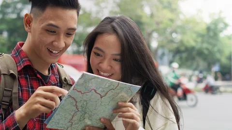 Handheld view of young couple with backpack reading map Video stock 126027767