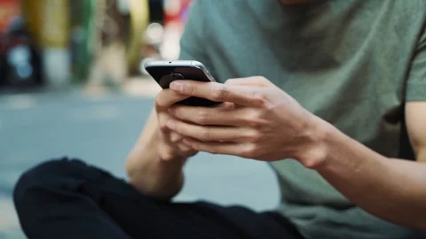 Handheld view of young man using mobile phone outdoors Video stock 125080187