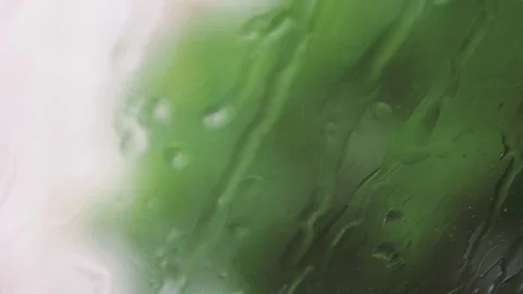Handheld: Windscreen wipers during a rain, blurry natural background Stock Footage 90518455