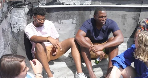 Handhelds shot of friends talking while having drinks at building terrace Video stock 120075621