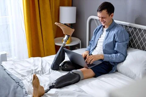 Handicapped guy using laptop for work or studies. New normal, social distancing Stock Photos