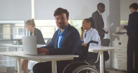Handicapped office manager looking at camera sitting in modern startup company Stock Footage 155489034