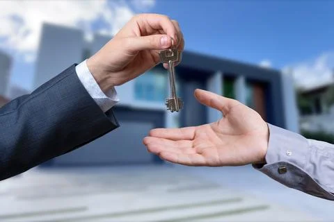 Handing Over the House Keys in Front of a Beautiful New Home. Stock Photos