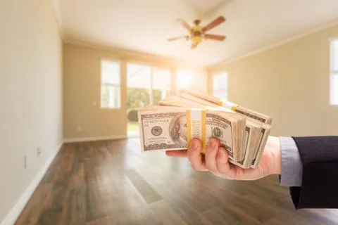 Handing Over Thousands of Dollars In Empty Room of House. Foto stock