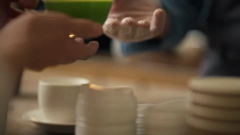 Handing over a vibrant green beverage in a bustling cafe setting during the Stock Footage 323806613