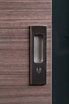 Handle door lock system on stylish wooden door, view from outside the room Stock Photos