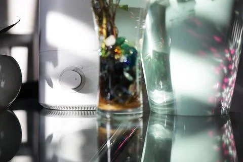 The handle of the humidifier on the table among the plants in the house Stock Photos