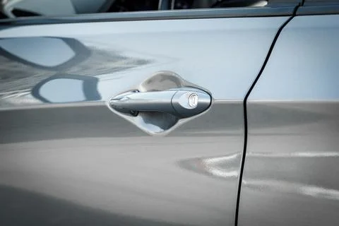 Handle with lock of a silver car door, close-up Stock Photos
