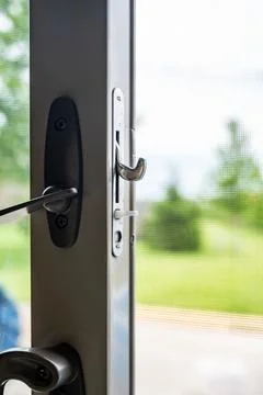 Handle, locking hardware, and jam to a sliding glass and screen door. Stock Photos