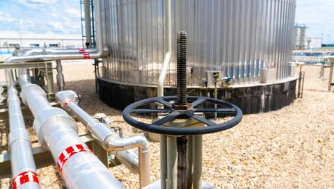 Handle of a manual vertical crane on a pipe coming out of a large tank Stock-Fotos