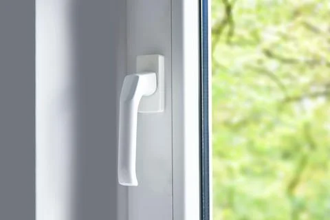 Handle of modern pvc plastic window in room, close up view Foto stock