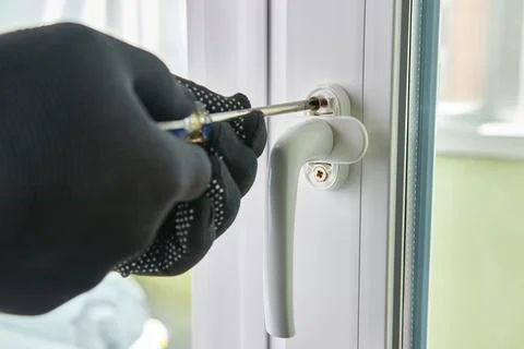 The handle is screwed to the window frame. Maintenance of metal-plastic win.. Stock Photos