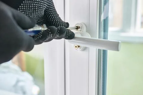 The handle is screwed to the window frame. Maintenance of metal-plastic win.. Stock Photos