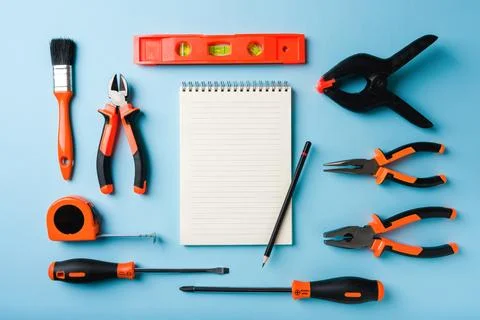 Handled tools or construction tools on blue background with blank notepad a.. Stock Photos