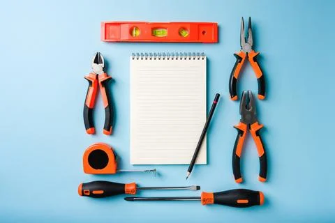Handled tools or construction tools on blue background with blank notepad a.. Stock Photos