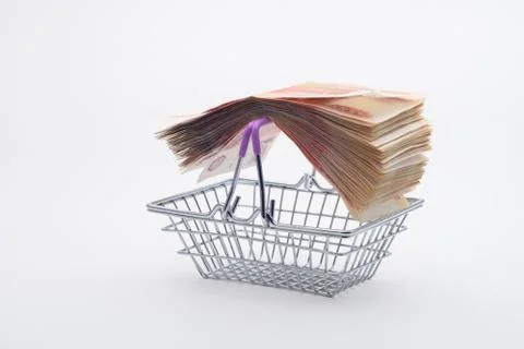 On the handles of the grocery basket is a large stack of paper bills, viewed  Stock Photos