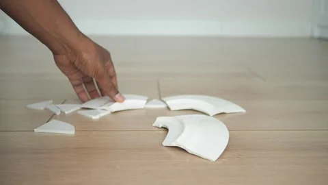 Handling broken ceramic pieces on the floor Stock Footage 314478526