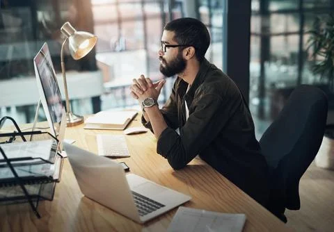 Handling business with razor sharp focus. a young businessman using a computer Stock Photos