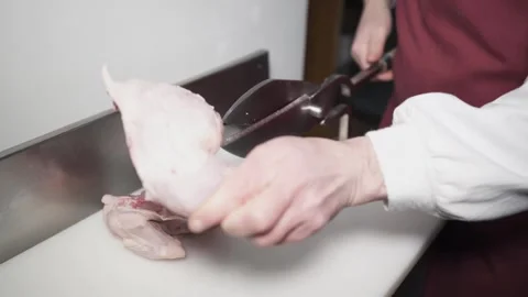 Handling of chopped chicken meat with fixed scissors on a work table. Vidéo 331913539