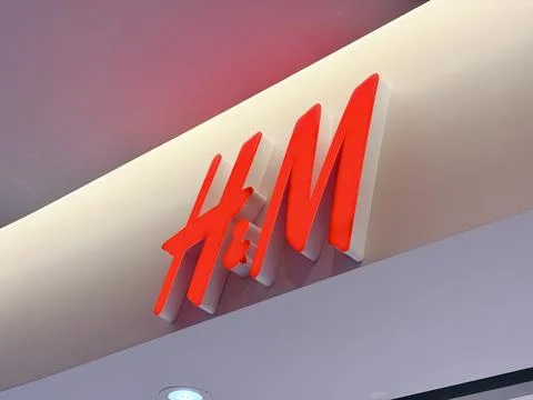 HandM store logo featuring the iconic red 3D script lettering on a clean wh.. Stock Photos