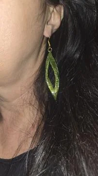 Handmade beaded and bugle bead earrings on a girl's ear. Product demonstratio Фото