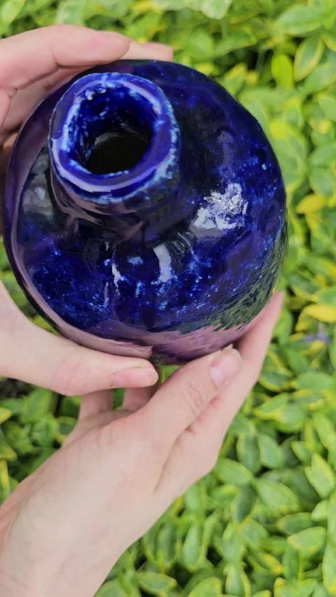 Handmade Blue Ceramic Vase Rotating in Hands Outdoors Video stock 324595128