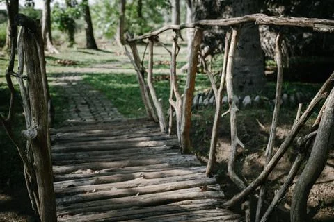 Handmade bridge from tree trunks and branches. Stock Photos
