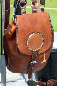 Handmade Brown Leather Backpack Hanging on Metal Rack Outdoors Stock Photos