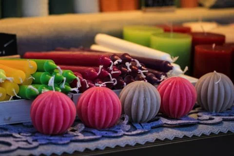 Handmade candles different forms and colors standing and lying on the table Stock Photos
