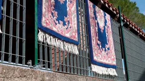 Handmade carpets with oriental patterns hanging on metal fence after washing Stock Footage 155804081