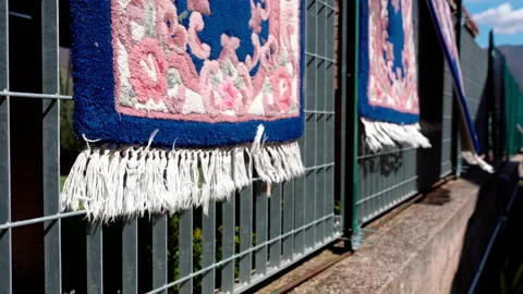 Handmade carpets with oriental patterns hanging on metal fence and waving Stock Footage 203837579