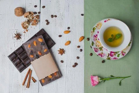 Handmade chocolate bar filled with different berries and nuts, cup of tea wit Stock Photos