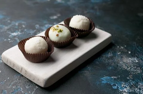 Handmade chocolates with cheese stuffing on a dark background. white milk Foto stock