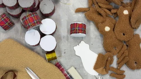 Handmade Christmas decorations in progress: plaid fabric drums, soft toy pieces, Stock Footage 325745954