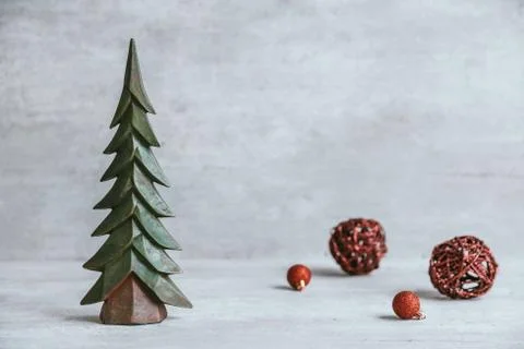 Handmade christmas tree on rustic gray wood table with red baubles. Stock Photos