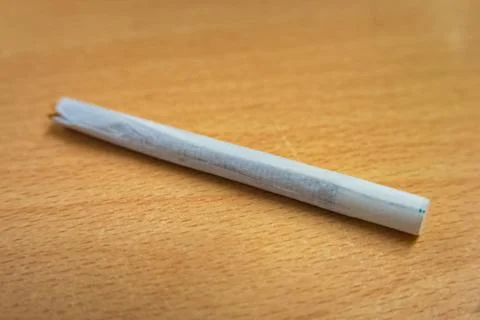 Handmade cigarette with paper filter lying on wood Stock Photos