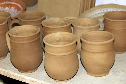 Handmade clay cups and pottery mugs in workshop studio shelf background 스톡 사진